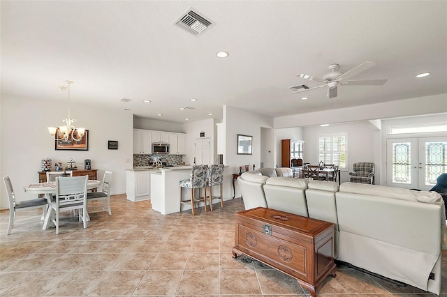 living room featuring french doors, ceiling fan with notable chandelier, and light tile patterned floors