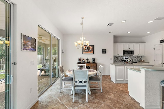 dining area with ceiling fan with notable chandelier