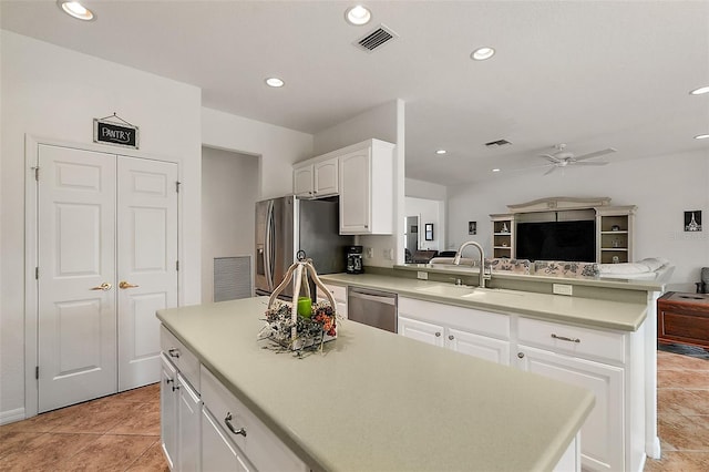 kitchen featuring a center island, sink, white cabinetry, kitchen peninsula, and appliances with stainless steel finishes