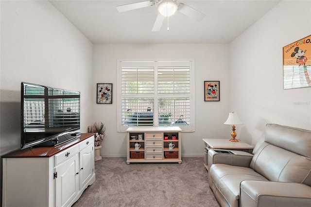 living area featuring light carpet and ceiling fan