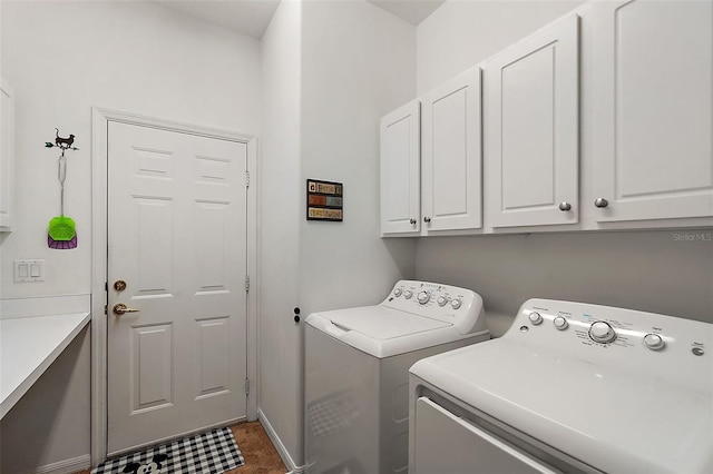 laundry area with cabinets, dark tile patterned flooring, and independent washer and dryer