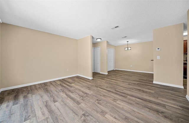 spare room with a textured ceiling and hardwood / wood-style floors