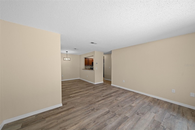 empty room with a textured ceiling and hardwood / wood-style floors