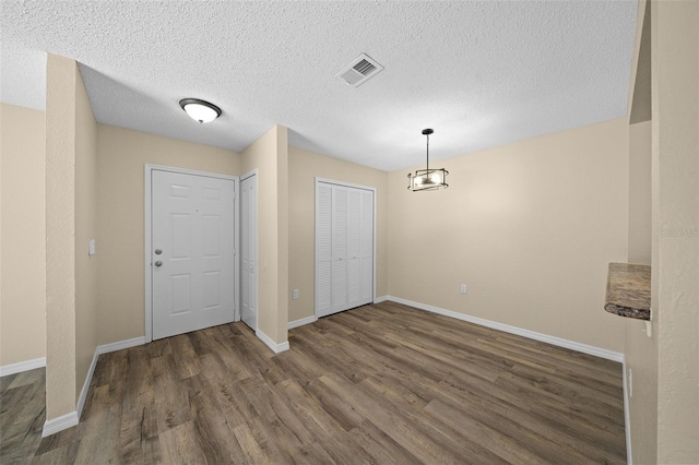 interior space featuring a textured ceiling and dark hardwood / wood-style floors