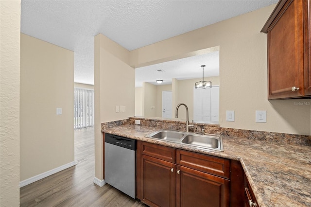 kitchen with light wood-type flooring, a textured ceiling, sink, and stainless steel dishwasher