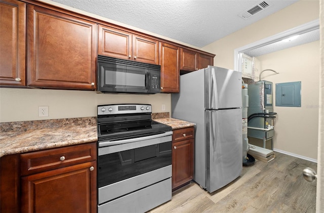 kitchen with light stone counters, electric panel, a textured ceiling, appliances with stainless steel finishes, and light hardwood / wood-style floors