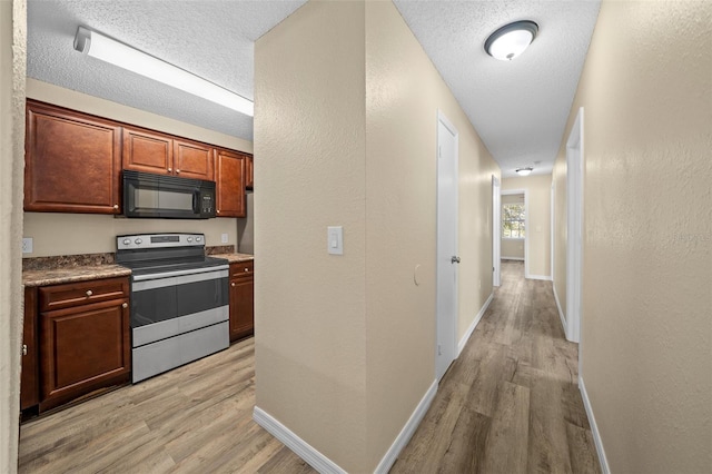 kitchen with stainless steel range with electric cooktop, a textured ceiling, and light hardwood / wood-style flooring