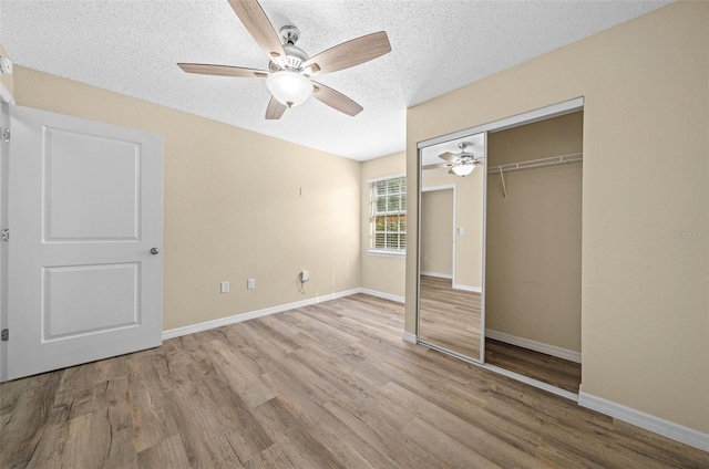 unfurnished bedroom with a textured ceiling, ceiling fan, light hardwood / wood-style flooring, and a closet