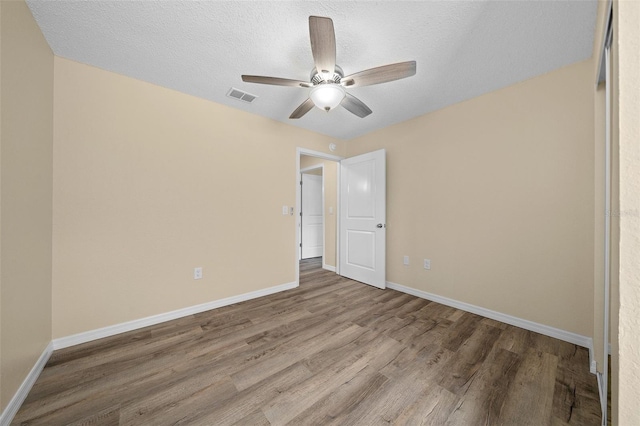 unfurnished bedroom with ceiling fan, a textured ceiling, and hardwood / wood-style floors