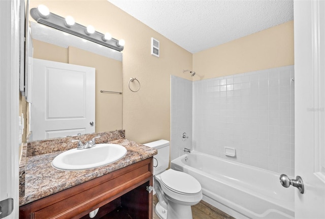 full bathroom featuring vanity, a textured ceiling, hardwood / wood-style flooring, toilet, and bathtub / shower combination