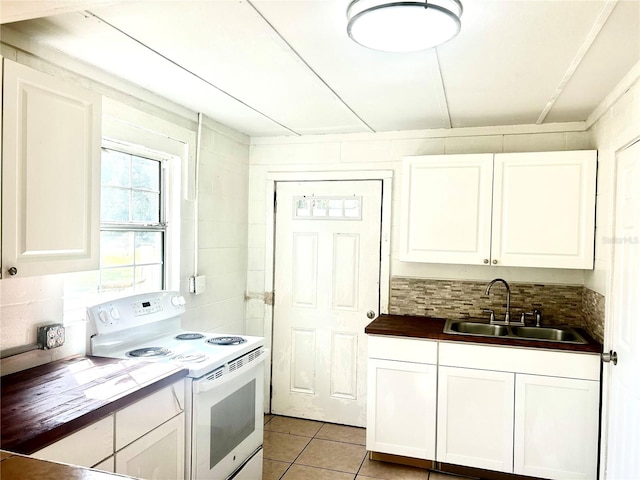 kitchen with white electric stove, white cabinetry, sink, and light tile patterned floors