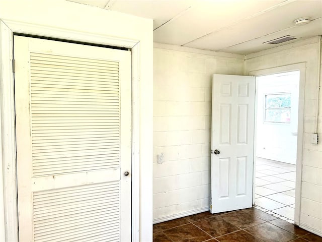 hall featuring dark tile patterned floors