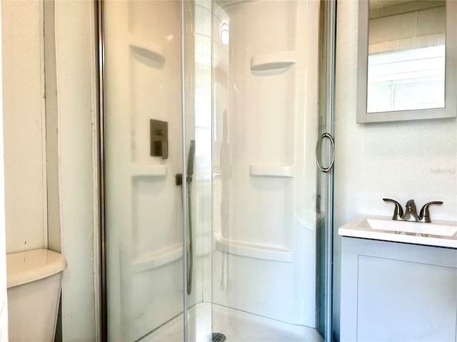 bathroom with vanity, an enclosed shower, and toilet