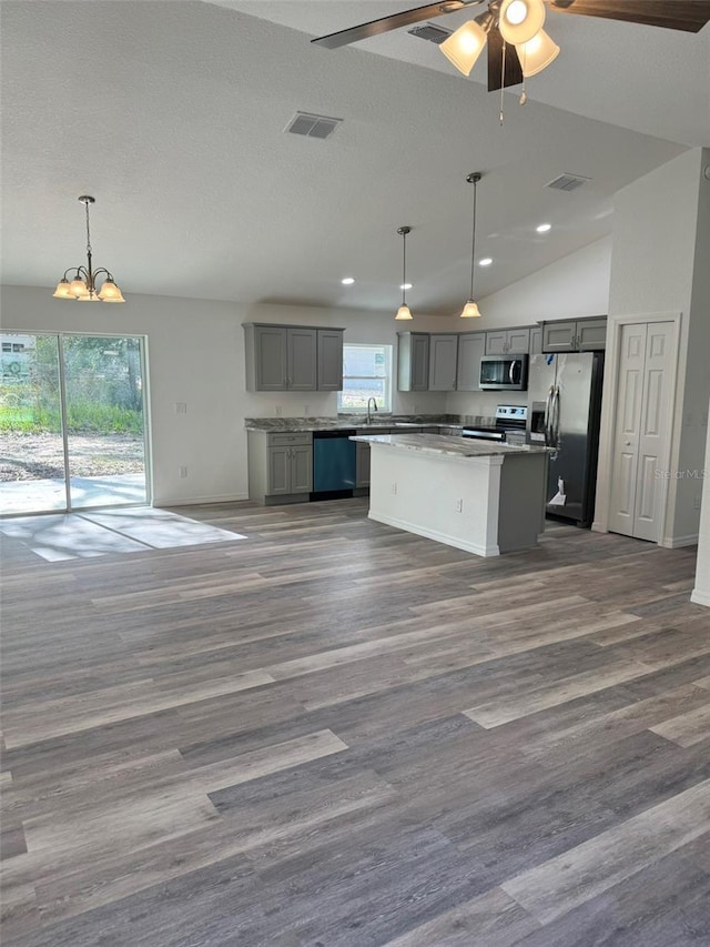 kitchen featuring gray cabinetry, decorative light fixtures, stainless steel appliances, and a center island