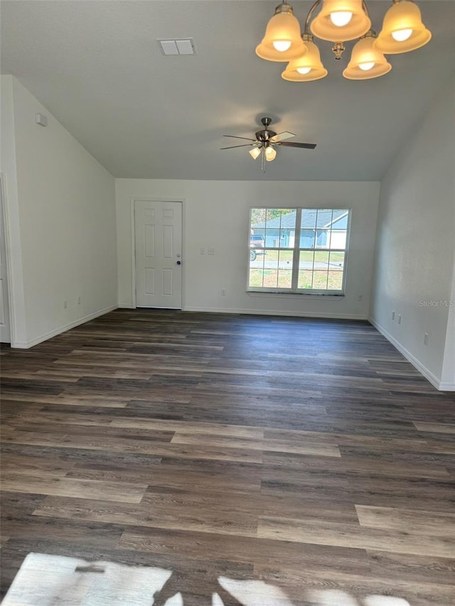 spare room featuring lofted ceiling, ceiling fan with notable chandelier, and dark hardwood / wood-style floors