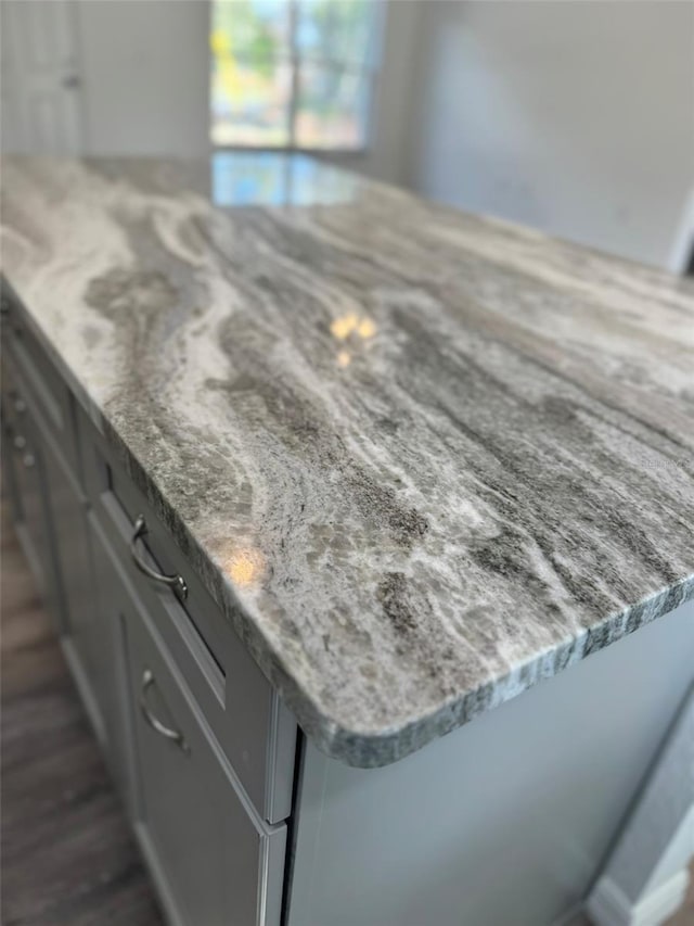 interior details featuring gray cabinets and light stone countertops