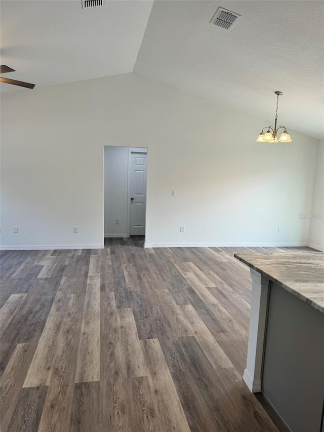 unfurnished living room featuring dark hardwood / wood-style flooring, ceiling fan with notable chandelier, and vaulted ceiling