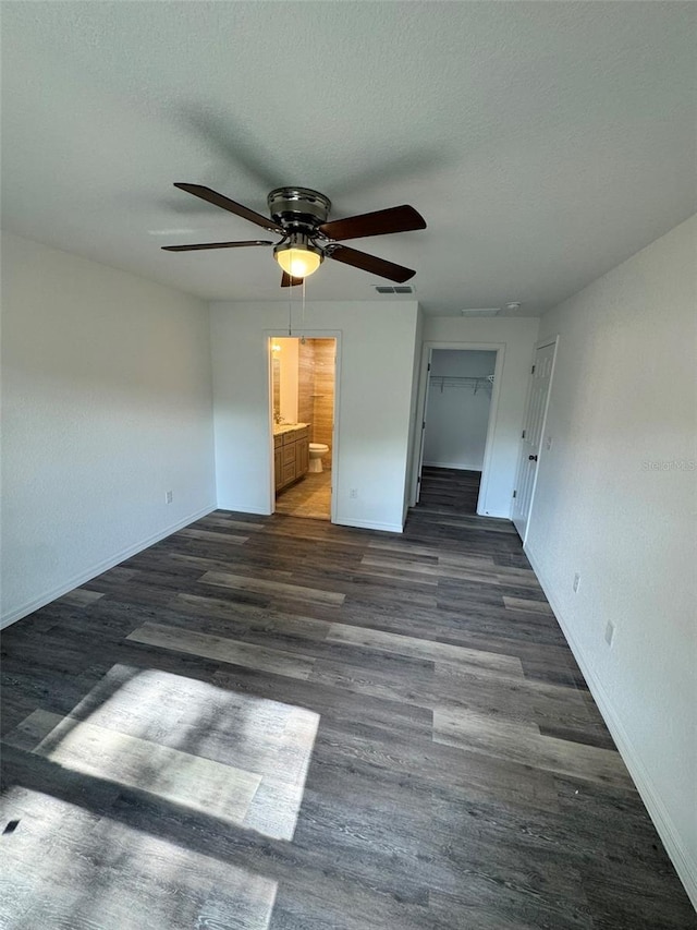 interior space with ensuite bathroom, dark hardwood / wood-style floors, and a textured ceiling