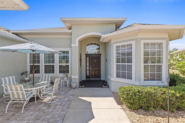 view of exterior entry with a patio area