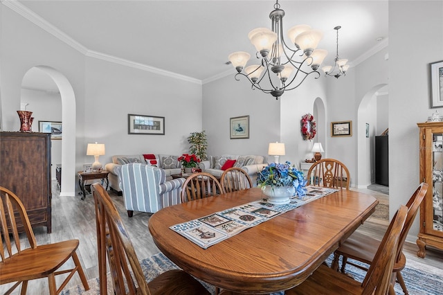 dining space with a notable chandelier, hardwood / wood-style flooring, and ornamental molding