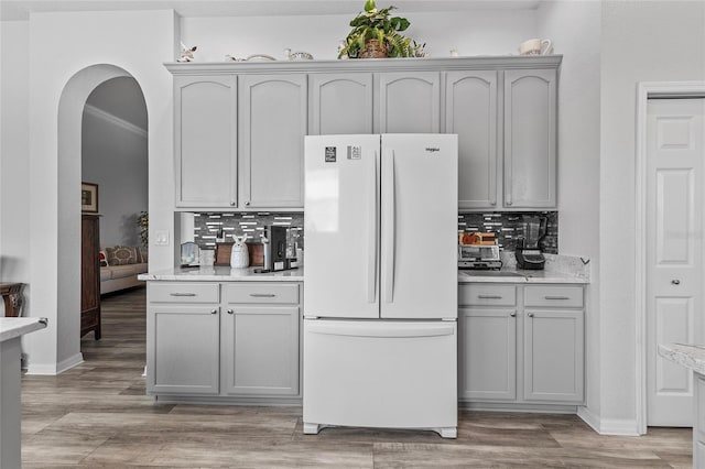 kitchen featuring tasteful backsplash, light hardwood / wood-style flooring, white fridge, and gray cabinetry