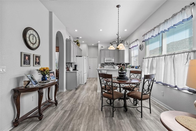 dining room with a notable chandelier and light hardwood / wood-style flooring