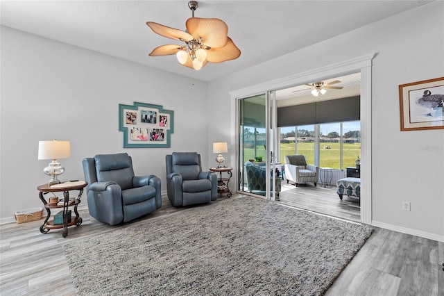 living area with ceiling fan and hardwood / wood-style floors