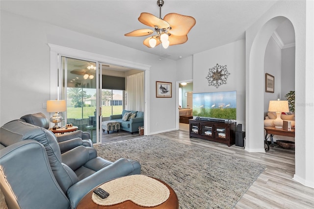 living room with ceiling fan, ornamental molding, and light hardwood / wood-style floors