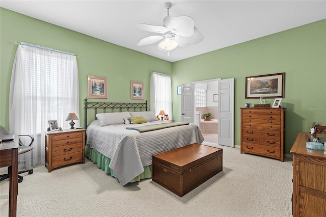 carpeted bedroom featuring ensuite bathroom and ceiling fan