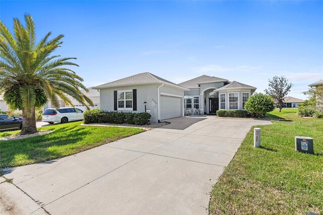 ranch-style home with a garage and a front lawn