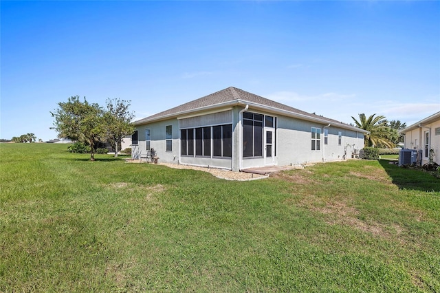 back of property featuring a sunroom, a lawn, and central air condition unit