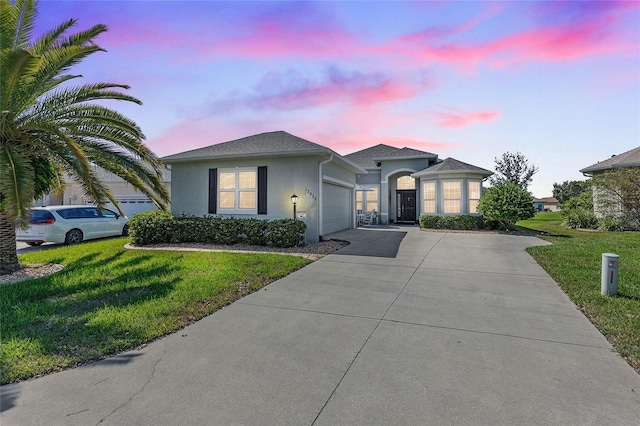 12333 SE 177th Loop, Summerfield, FL 34491 - view of front of home featuring a garage, driveway, stucco siding, and a front yard