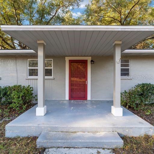 view of exterior entry featuring covered porch