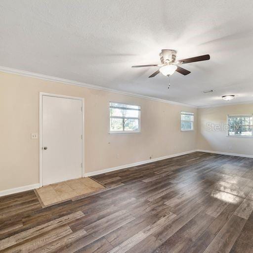 spare room featuring ornamental molding, ceiling fan, dark hardwood / wood-style floors, and a textured ceiling