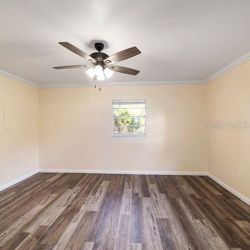 spare room featuring crown molding, dark hardwood / wood-style floors, and ceiling fan