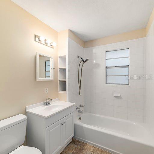 full bathroom featuring vanity, toilet, and tiled shower / bath