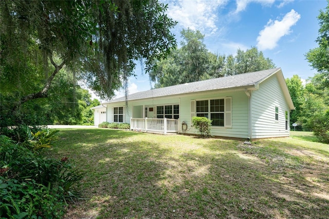 rear view of property featuring a yard