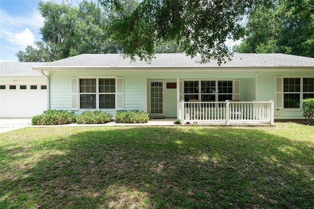 single story home with a porch, a garage, and a front yard