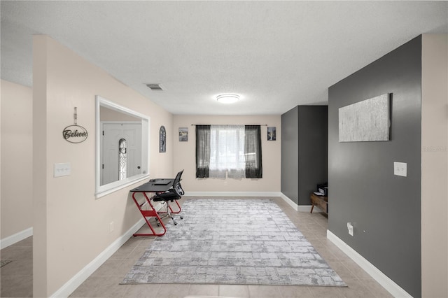 interior space featuring a textured ceiling and light tile patterned floors