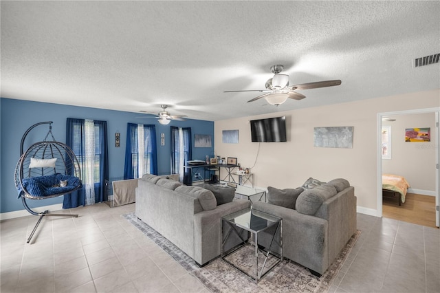 tiled living room with ceiling fan, a textured ceiling, and a healthy amount of sunlight