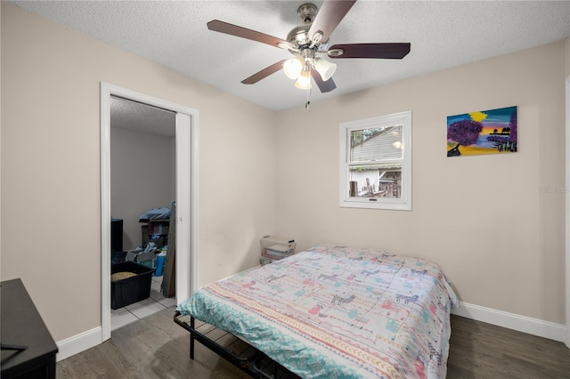 bedroom featuring a textured ceiling, dark hardwood / wood-style flooring, and ceiling fan