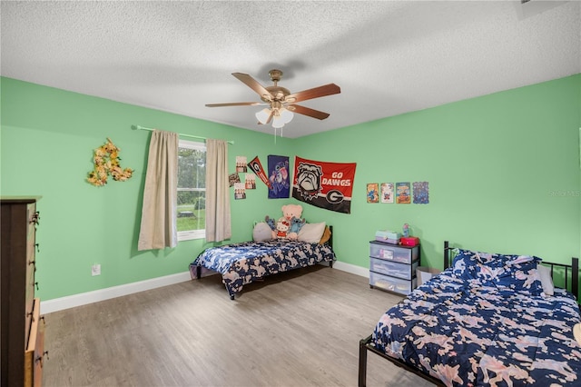 bedroom featuring a textured ceiling, ceiling fan, and hardwood / wood-style flooring