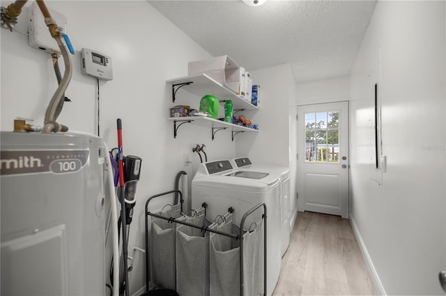 laundry area featuring separate washer and dryer, a textured ceiling, and light wood-type flooring