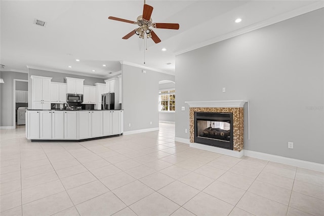 unfurnished living room featuring crown molding, light tile patterned floors, a multi sided fireplace, and ceiling fan