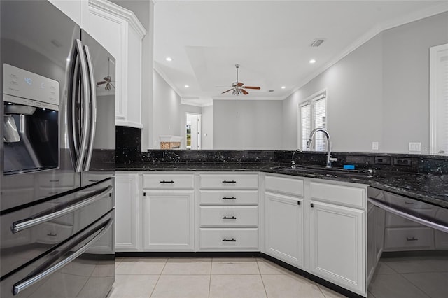 kitchen with dark stone countertops, appliances with stainless steel finishes, white cabinetry, and sink