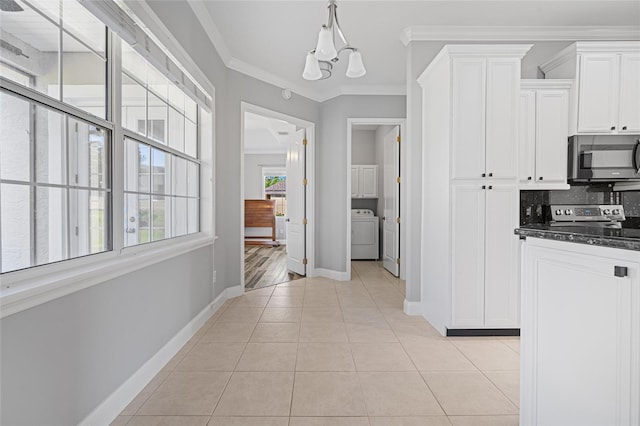 kitchen featuring washer / clothes dryer, stainless steel appliances, crown molding, white cabinets, and tasteful backsplash