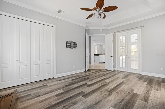 unfurnished bedroom featuring french doors, ornamental molding, wood-type flooring, and ceiling fan