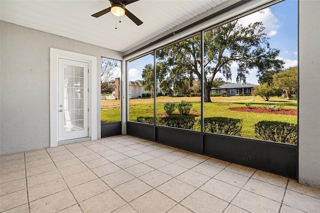 unfurnished sunroom with ceiling fan