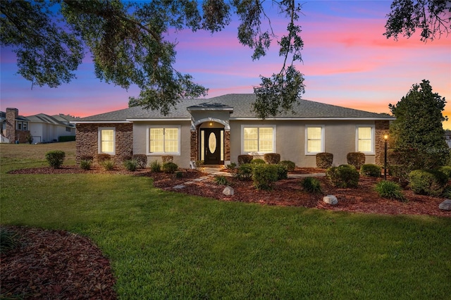 ranch-style home with a yard