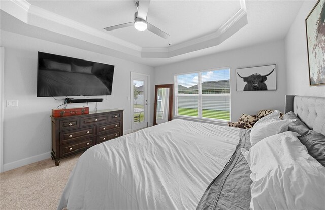 carpeted bedroom featuring access to outside, a tray ceiling, ceiling fan, and crown molding